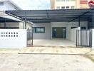 Entrance of a modern residential building with gated front porch and covered parking area