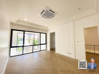 spacious living room with large windows and modern ceiling fixture