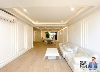 Spacious living room with modern recessed lighting and wooden flooring