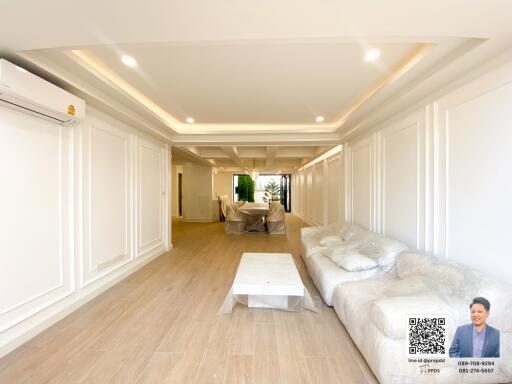 Spacious living room with modern recessed lighting and wooden flooring