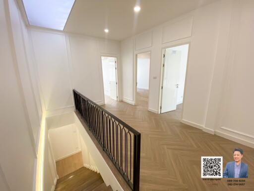 Bright modern hallway with wooden flooring and staircase