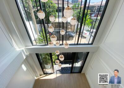 View from upper floor overlooking large windows with hanging ceiling lights