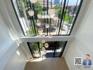 View from upper floor overlooking large windows with hanging ceiling lights