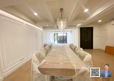 Spacious dining room with a large table and modern chandelier