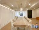 Spacious dining room with a large table and modern chandelier