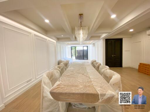 Spacious dining room with a large table and modern chandelier