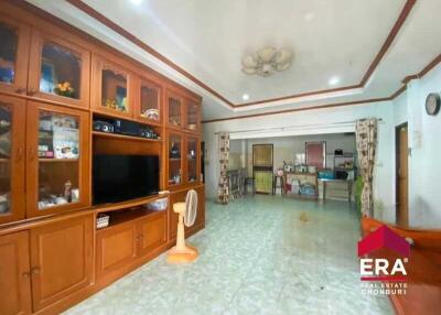 Spacious living room with wooden cabinetry and a ceiling fan