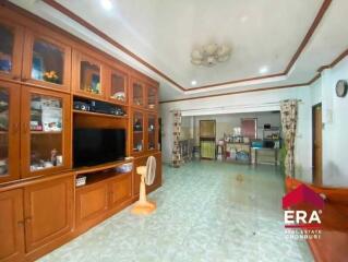 Spacious living room with wooden cabinetry and a ceiling fan