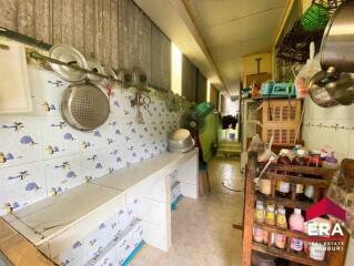 Narrow kitchen with wall-mounted utensils and storage shelves