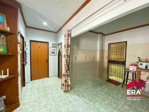 Main living area with tiled floor, wooden door, and windows