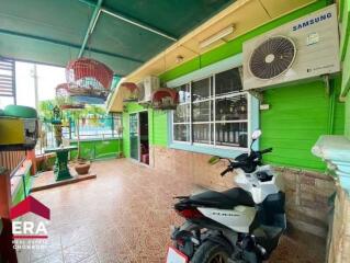 Outdoor area with green walls, tiled floor, bird cages, and a parked motorbike