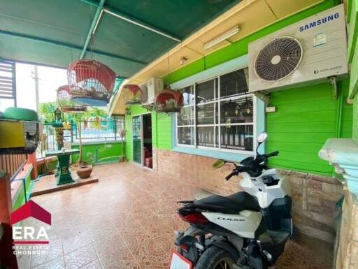 Outdoor area with green walls, tiled floor, bird cages, and a parked motorbike