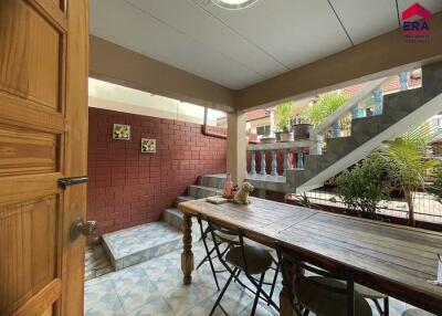 Outdoor dining area with table, chairs, and staircase