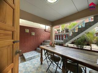 Outdoor dining area with table, chairs, and staircase