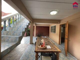 Covered patio area with wooden table and chairs