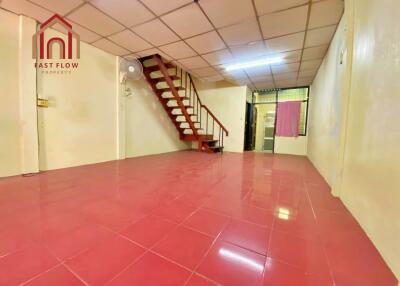 Spacious living area with red tiled floor and stairway