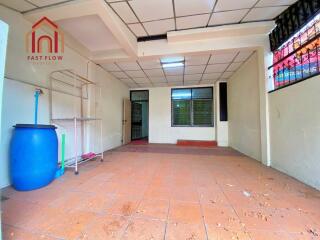 Empty indoor space with tiled floor and ceiling grid