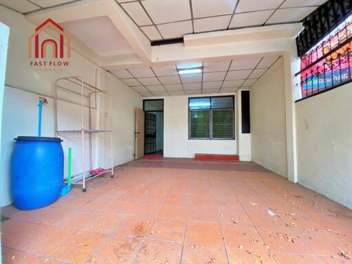 Empty indoor space with tiled floor and ceiling grid