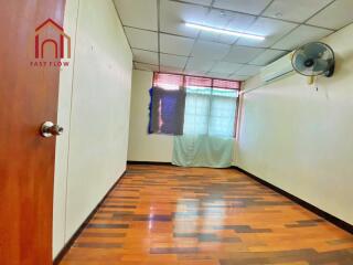 Spacious bedroom with wooden floor and large window