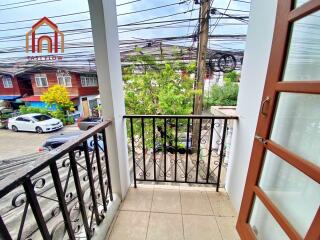 A small balcony with a metal railing overlooking the street