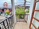 A small balcony with a metal railing overlooking the street