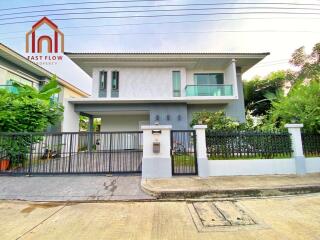 Modern two-story house with a front yard and gated driveway