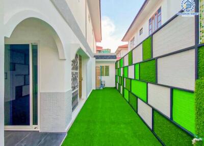 Exterior walkway with vibrant green artificial grass and colorful wall panels