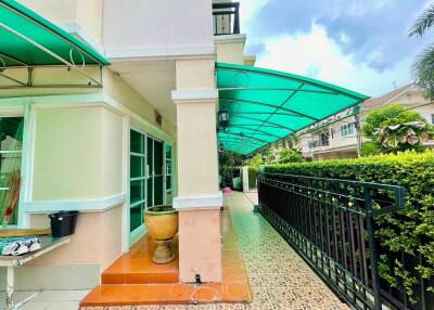 Front view of a building with green awnings and a walkway