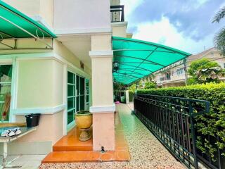 Front view of a building with green awnings and a walkway