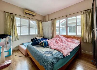 Bedroom with large windows, air conditioner, and double bed