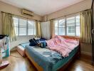 Bedroom with large windows, air conditioner, and double bed