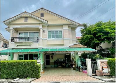 Two-story house with a green awning.