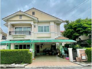 Two-story house with a green awning.