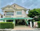 Two-story house with a green awning.