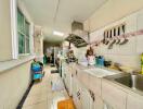 Spacious kitchen with long countertop and various cooking utensils