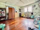 Spacious bedroom with wooden floors and natural light