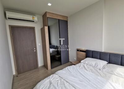 Modern bedroom with bed, wardrobe, and air conditioning unit