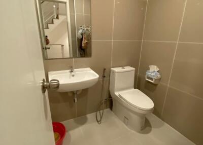 Modern bathroom with toilet, sink, and mirror