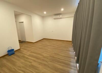 Spacious living room with wooden flooring and large windows