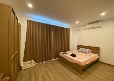 Modern bedroom with wooden furniture and laminate flooring