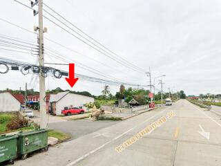 Photo of a building by the roadside with electrical wires and a red truck parked nearby