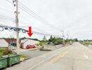 Photo of a building by the roadside with electrical wires and a red truck parked nearby