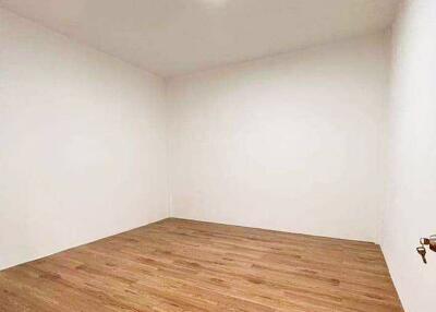 Minimalistic empty room with hardwood floors and white walls