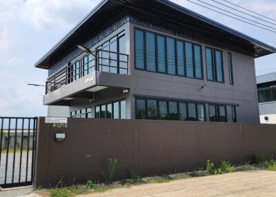 Modern two-story building with large windows and a gated entrance