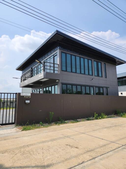 Modern two-story building with large windows and a gated entrance