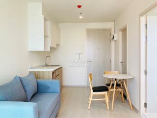 Modern living area with mini kitchen, couch, and dining table