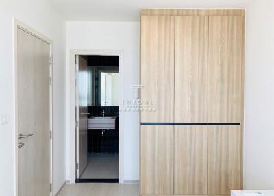 Bedroom with wooden wardrobe and view into bathroom