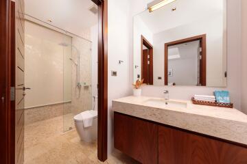 Modern bathroom with glass-enclosed shower and wooden cabinetry