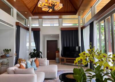 Spacious living room with vaulted wooden ceiling and large windows