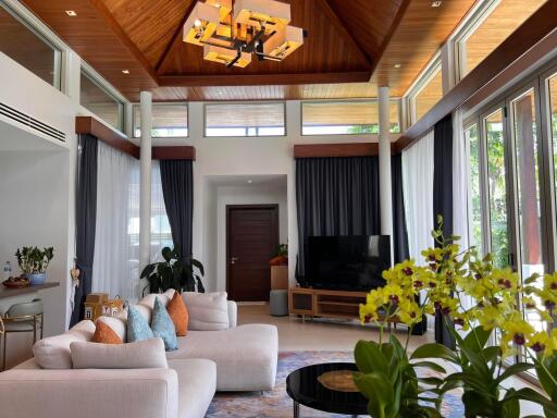 Spacious living room with vaulted wooden ceiling and large windows